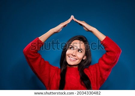 Photo of cheerful cute brown hair lady look hold hands up wear red sweater isolated on blue color background
