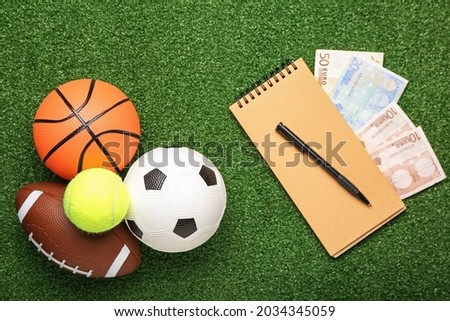 Money, notebook and balls on color background. Concept of sports bet Royalty-Free Stock Photo #2034345059