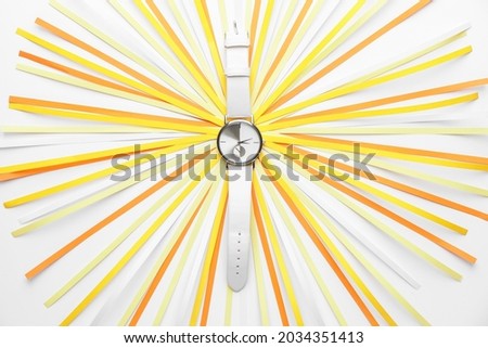 Wrist watch with paper strips on white background