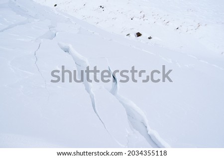 Cracks in the snow before the avalanche begins. Royalty-Free Stock Photo #2034355118