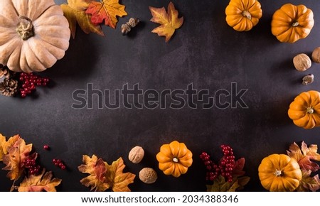 Autumn composition. Pumpkin, cotton flowers and autumn leaves on dark stone background. Flat lay, top view with copy space