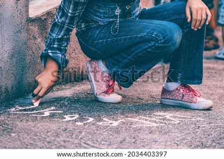 Back to school concept- Girl writing with chalk on the schoolyard