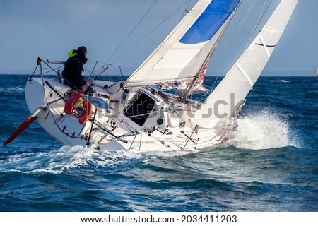 solitary skipper sailing on yacht  Royalty-Free Stock Photo #2034411203
