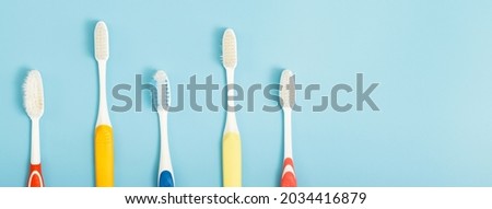 The old toothbrush used expired (damaged) variety of colors on the blue background. concept Used for manufacturing health industry Professional dentist or often should change your toothbrush. 