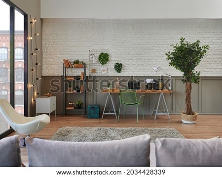 Decorative living room and working from home, interior concept, wooden desk, laptop, green plant.