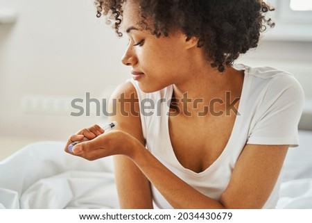Serious woman patient giving herself an injection Royalty-Free Stock Photo #2034430679
