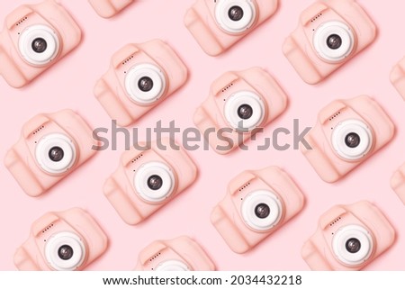 Small lovely girls pink digital camera inspired pattern. Minimal flat lay monochromatic arrangement against baby pink background.