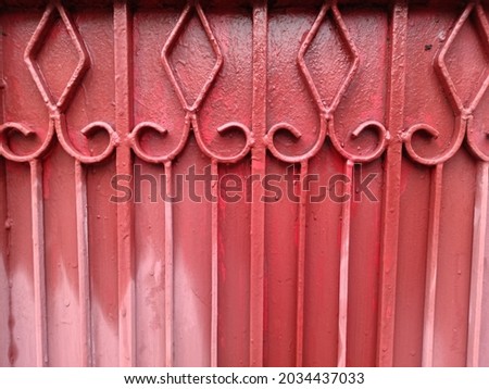 patterned iron fence ,
red metal gate with a wicket