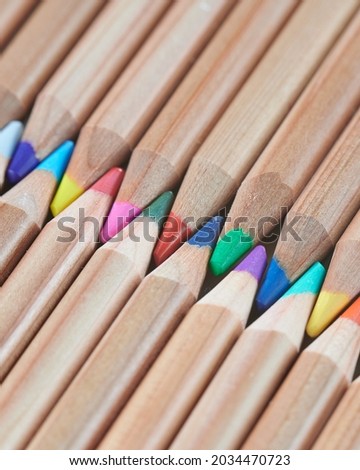 Exactly laid out colored wooden pencils. Background new pencils.