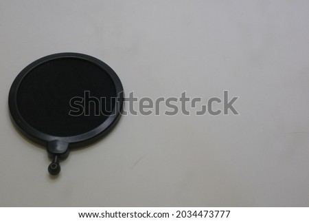 Black color of microphone pop filter on white isolated background photo