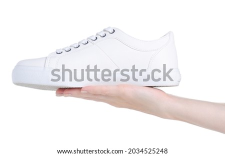 White leather sneakers in hand on white background isolation