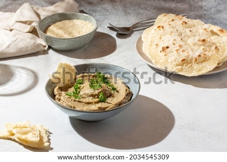 Baba ghanoush, babaganush or baba ganoush in gray bowl served with  oriental flatbread on concrete background. Turkish cuisine.  Royalty-Free Stock Photo #2034545309