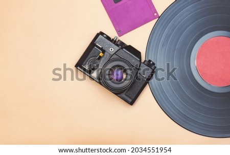 An old vinyl record, a film camera and a floppy disk for a computer are  reminder of the rapid progress in the field of high technologies