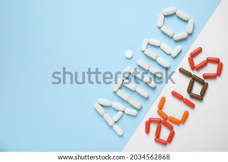 Words "AMINO ACIDS" made with pills on color background, flat lay. Space for text