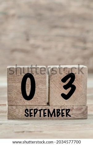 closeup cube calendar for september on a wooden background with copy space, vertical