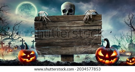 Halloween Card Party - Pumpkins And Zombies In Graveyard With Wooden Board Royalty-Free Stock Photo #2034577853