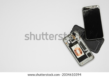 Damaged smartphone on white background, flat lay with space for text. Device repairing