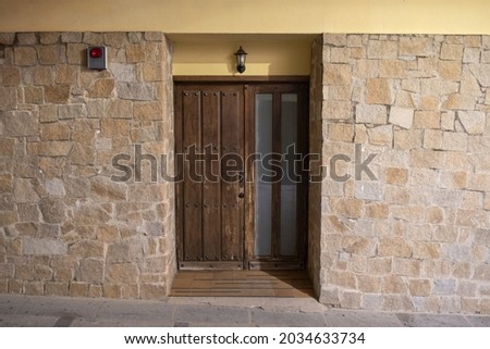 wooden entrance door to house with alarm