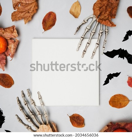Blank square canvas frame and Halloween decorations on grey background. Flat lay design. Mockup poster for Halloween congratulations.