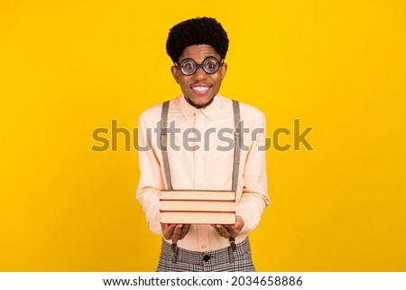 Photo portrait man in shirt wearing glasses keeping book pile isolated bright yellow color background