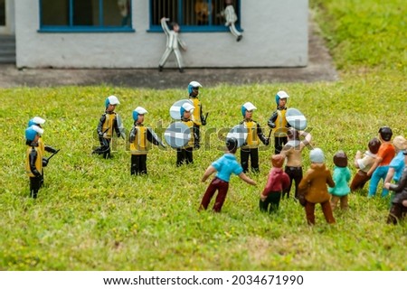 Closeup photo of tiny model riot police and protesters having a confrontation