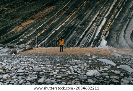 woman with yellow raincoat in a flysch Royalty-Free Stock Photo #2034682211