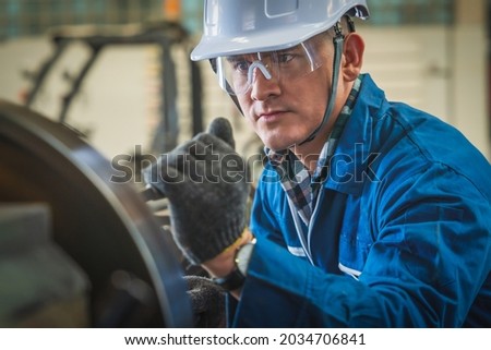 Industrail background of portrait of mechanic engineer operating lathe machine to make metal part in metalwork workshop and factory Royalty-Free Stock Photo #2034706841