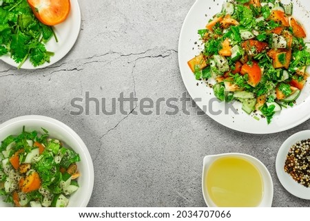 Lazy Mediterranean salad with tomatoes, cucumber, coriander, onions, olive oil and lemon in a white ceramic plate selective focus. Healthy vegetarian food, oriental and Mediterranean cuisine. Top view Royalty-Free Stock Photo #2034707066