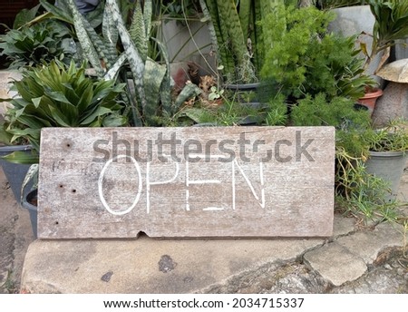 OPEN letter on wooden board decoreted in the garden 