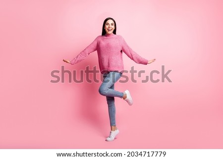 Full body portrait of cheerful pretty lady dance hands sides flying raise knee isolated on pink color background