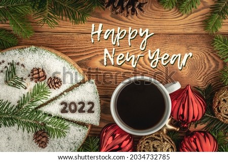 Card with a cup of coffee and festive cake decorated the number 2022 made of chocolate and the inscription Happy New Year. Top view .