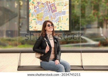 Young woman waiting for public transport at bus stop