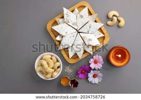 Kaju Katli is a traditional Indian Diamond shaped sweet or Mithai made using cashew paste, sugar, and mava or Khoya. served in a wooden plate over dark background. cashew barfi. Copy space Royalty-Free Stock Photo #2034758726