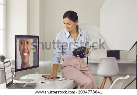 Happy creative young freelance photographer looking at computer screen, post processing diverse beauty commercial photo shoot, working with modern editing software, doing color correction and grading