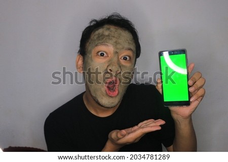 Shock Asian Man showing blank screen  when he use beauty face mask