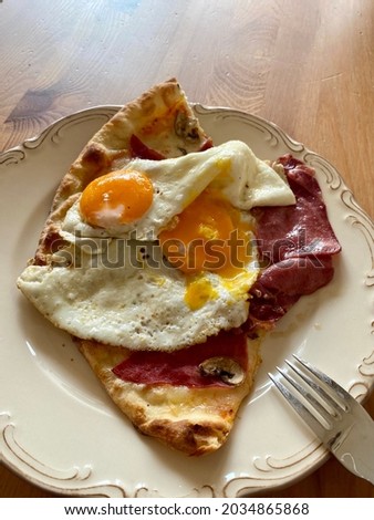 Pizza Slice with Fried Egg Reheated for Breakfast Plate.