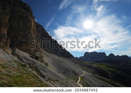 Scenic route from Rifugio Auronzo to Rigugio Lavaredo along Tre Cime mountain range with sun in the picture