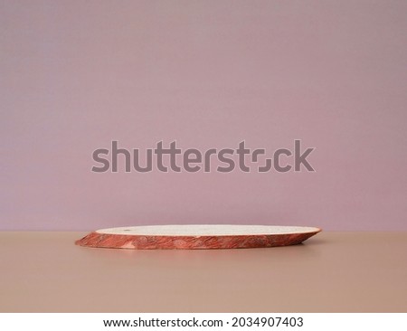 Oval cylinder from sawn wood on a pastel background for mock-up, front view. Empty wooden geometric podium. Trendy product stand display showcase for cosmetic products and goods. Copy space.