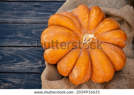 pumpkin on a black wooden background, still life for Halloween or Thanksgiving, space for text, copy space