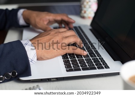 Selective focus shot of closeup hands typing on laptop computer keyboard. Horizontal, copy space for text. 