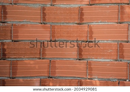 Close up of a wall made with orange bricks and cement