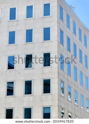 Corner of minimal building facade with simple glass windows. Vertical photo