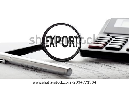 Magnifying glass with text EXPORT on chart with pen and calculator