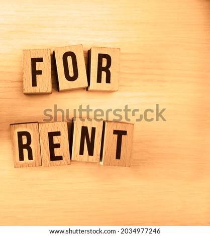 Close-up image  Of Small House Model On Wooden Blocks With Rent Guarantee Text Over Table. top view. empty copy space.