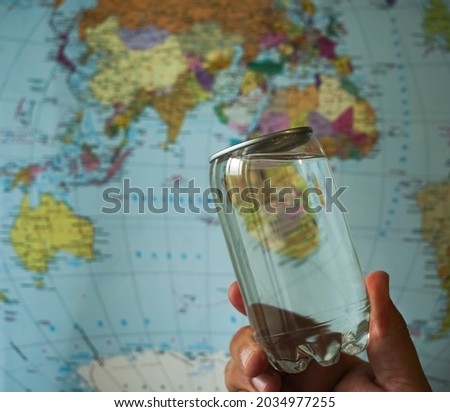 plastic can with pure drinking water on globe map background. transparent bottle 