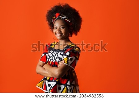 cute african young woman in traditional dress on red background  Royalty-Free Stock Photo #2034982556