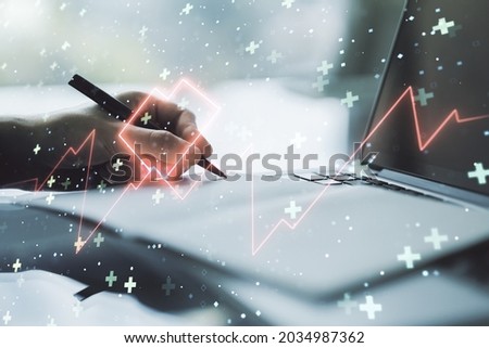 Creative concept of heart pulse illustration and hand writing in notebook on background with laptop. Medicine and healthcare concept. Multiexposure