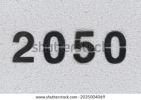 Black Number 2050 on the white wall. Spray paint. Number two thousand and fifty.