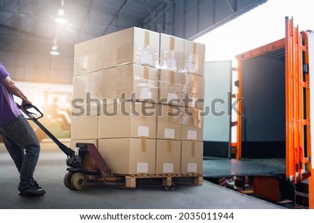 Workers Courier Unloading Packaging Boxes pallets into Shipping Container. Delivery Man. Truck Loading at Dock Warehouse. Supply Chain. Shipments. Shipping Warehouse Logistics and Cargo Transport.	 Royalty-Free Stock Photo #2035011944