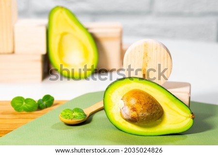Halves of Ripe Avocado and micro green on wooden board served on table, white background, Healthy oily food, Keto diet, Close up.